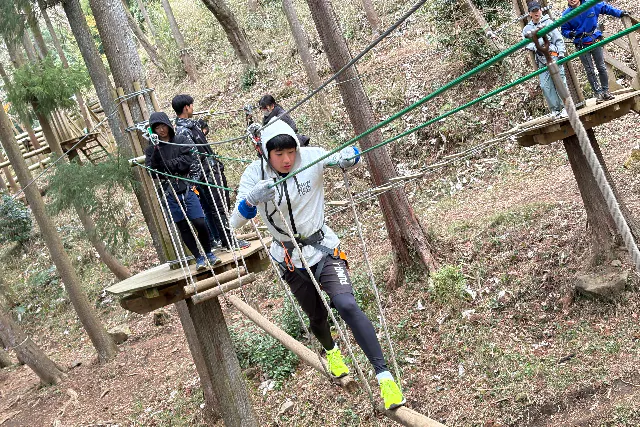 アドベンチャーコースの細い橋を渡る参加者
