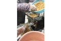 茹でてやわらかくなった大豆を、機械に入れて潰していきます。
